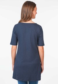 Navy blue tunic with short sleeves, made of soft fabric. Features a rounded neckline and a loose fit that falls below the hip.