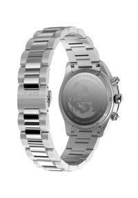 Sudraba nerūdīga tērauda pulkstenis ar saistītu siksniņu, hronogrāfa funkcijām un lāzermarkētu aizmugurējo vāciņu, kurā attēlota zīmola logo un pasaules karte.