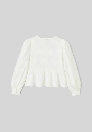 Blouse blanche à manches longues avec broderie florale, encolure ronde et bas à volant. Manches froncées et poignets à boutons. Tissu texturé.