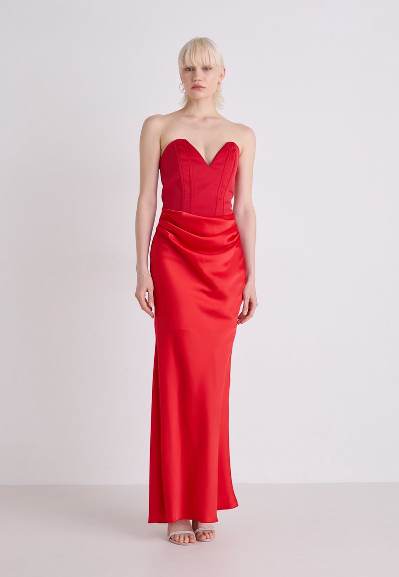 Rochie de seară din satin roșu, cu decolteu strapless în formă de inimă, cu corset ajustat și fustă drapată. Textură netedă, design până la podea, detalii minime.