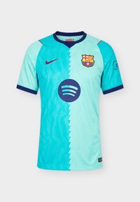 Φανέλα ποδοσφαίρου της FC Barcelona σε δύο αποχρώσεις του μπλε με το έμβλημα του συλλόγου, το λογότυπο της Nike και το λογότυπο του χορηγού Spotify στο μπροστινό μέρος.