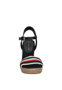 Sandal con zeppa e suola in corda di juta, dotata di cinturino alla caviglia nero e tomaia in tessuto a strisce multicolori nei toni del blu, rosso e crema.