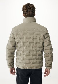 Giacca puffer beige con texture trapuntata, colletto alto e polsini a coste. Il retro presenta un design liscio e una vita semplice.