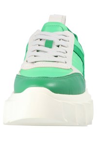 Grön och vit sneaker med en kraftig sula, läder- och textilmaterial, framträdande snörning och ett randigt mönster längs sidorna.