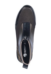 Bottine marron avec un dessus en cuir lisse, des accents à imprimé léopard et une fermeture éclair à l'avant. Présente un bout rond et une languette à l'arrière.