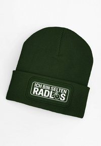 Green knitted beanie with ribbed texture and a folded cuff. Features a rectangular white graphic patch with the text "ICH BIN SELTEN RADLOS."