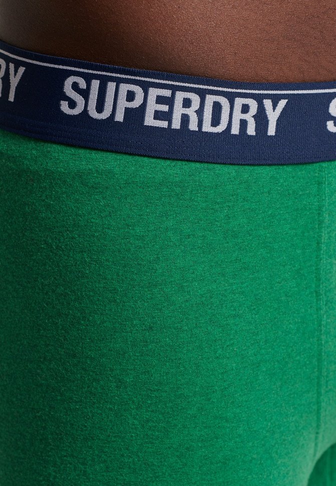 Groene katoenmix boxershorts met een marineblauwe elastische tailleband waarop het "SUPERDRY"-logo in het wit is gedrukt. Zachte textuur, aangesloten ontwerp.