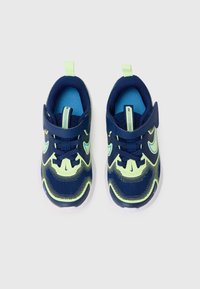 Baskets de sport bleues et vert néon avec une tige en maille, une sangle Velcro, un bout arrondi et une semelle texturée pour une meilleure adhérence.