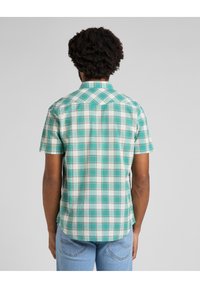 Kurzarm-Hemd aus Karo in Teal, Weiß und Grün. Verfügt über einen Umlegekragen, einen Rückensteg und einen geraden Saum auf Taillenhöhe.