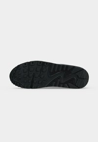 Μαύρη λαστιχένια σόλα ενός παπουτσιού Nike με λεπτομερή σχεδιασμό πέλματος και το λογότυπο Nike Air στο κέντρο.