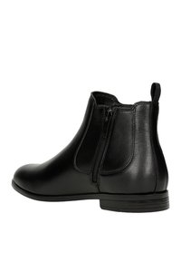 Schwarze Leder-Chelsea-Boots mit einem seitlichen Reißverschluss, abgerundeter Zehe und flacher Gummisohle. Glatte Textur mit einem eleganten Design und minimalen Akzenten.