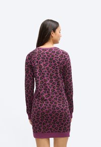 Vijolična obleka z leopardjim potiskom, dolgimi rokavi, rebrastimi manšetami in zaobljenim izrezom. Mehka tkanina z udobnim krojem.