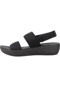 Zwarte wedge-sandalen met twee brede stoffen banden en een verstelbare achterkant. De zool is textuur en biedt een lichte verhoging.