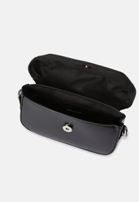 Černá crossbody taška z umělé kůže s klopou, stříbrným zacvakávacím knoflíkem a podšívkou z látky. Kompaktní obdélníkový tvar.
