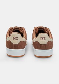 Sneaker in suede marrone con accenti beige, collarino imbottito e suole bianche. Presenta un logo impresso sul tallone e lacci texturizzati.