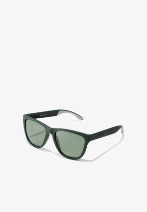 Matt sötétzöld napszemüveg szögletes kerettel, zöld lencsékkel és szürke szárdíszítéssel. Az oldalán a "HAWKERS" márkanév látható.