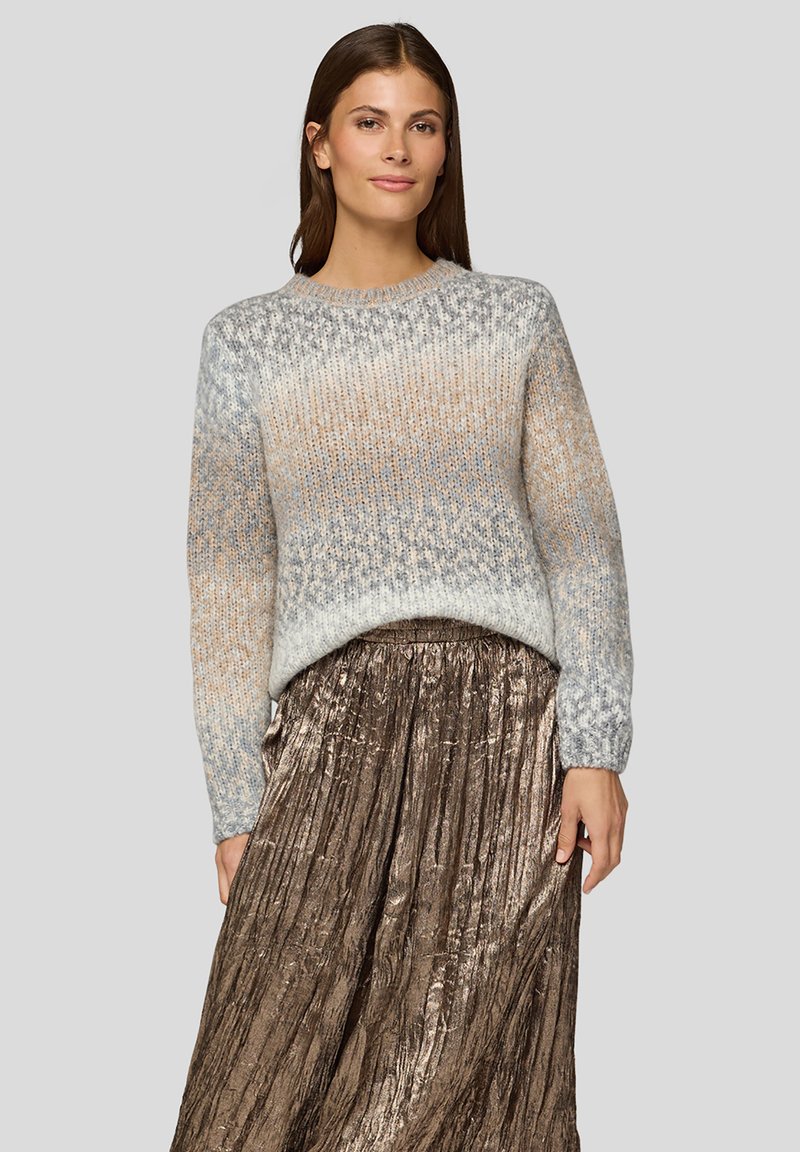 Gestrickter Pullover in einem Ombre-Muster aus Hellgrau, Beige und Blau, mit Rundhalsausschnitt und langen Ärmeln, kombiniert mit einem plissierten, metallisch bronzefarbenen Rock.