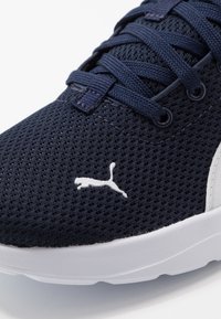 Granatowy siateczkowy sneaker z fakturowaną powierzchnią, białą gumową podeszwą i białym logo Puma po boku. Sznurowadła w dopasowanym granatowym kolorze.
