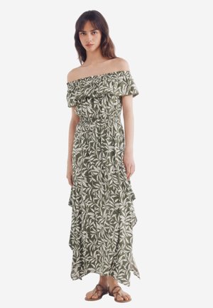 Schulterfreies, grünes Maxikleid mit floralen Mustern, Rüsche am Halsausschnitt und gestuften Saum. Hergestellt aus leichtem Stoff und mit weißen Blättermustern versehen.