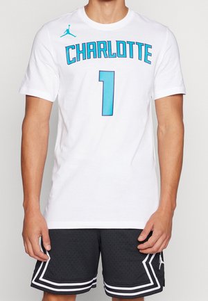 Witte T-shirt met korte mouwen met "CHARLOTTE" in turkooise letters en een groot turkoois nummer "1", met een Jumpman-logo op de schouder.
