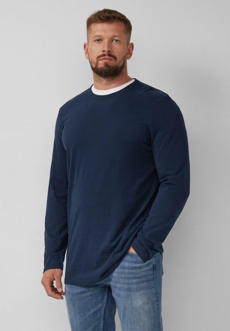Marineblauwe shirt met lange mouwen en een ronde halslijn, met een contrasterende witte binnenkraag. Zachte stof met minimale rek.