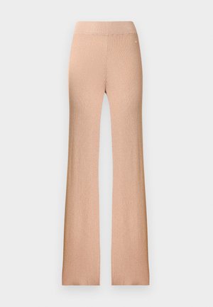 Pantaloni evazaţi cu talie înaltă, cu textură nervurată, dintr-un material moale bej. Prezintă o suprafață texturată și picioare evazate, finisate cu un detaliu subtil de logo.