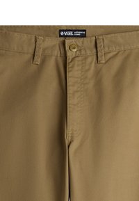 Ruske chinos hlače od pamuka s glatkom teksturom, s prednjim zatvaranjem na dugme, petljama za remen i brendiranim etiketom na struku.