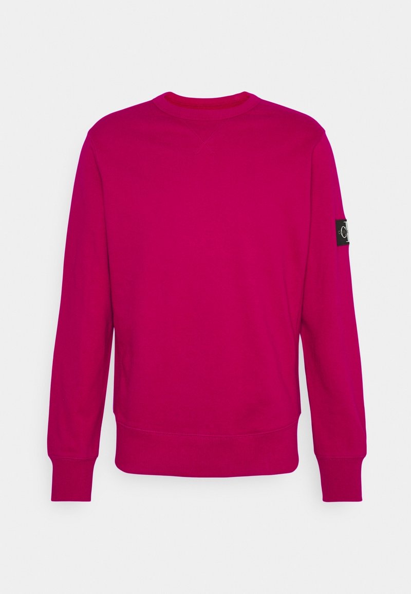 Heldere fuchsia sweatshirt met lange mouwen, een geribde ronde hals en geribde manchetten. Voorzien van een logopatch op de linker mouw. Gladde textuur.