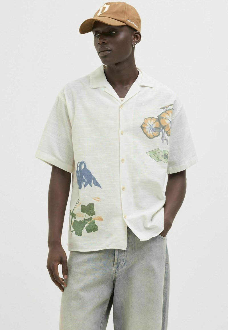 Short-sleeve button-up shirt in light fabric, features floral prints in blue and orange, with a relaxed fit and subtle texture.