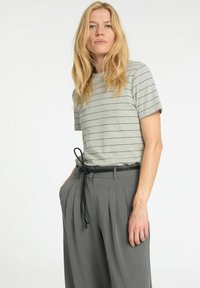 Gråstribet t-shirt med korte ærmer og rund halsudskæring, parret med højtaljede grå bukser med folder og et sort bælte.