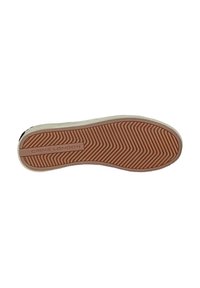 Semelle en caoutchouc de sneaker avec un motif en chevron orange et blanc. Présente un patch logo en relief avec "CRIME LONDON."