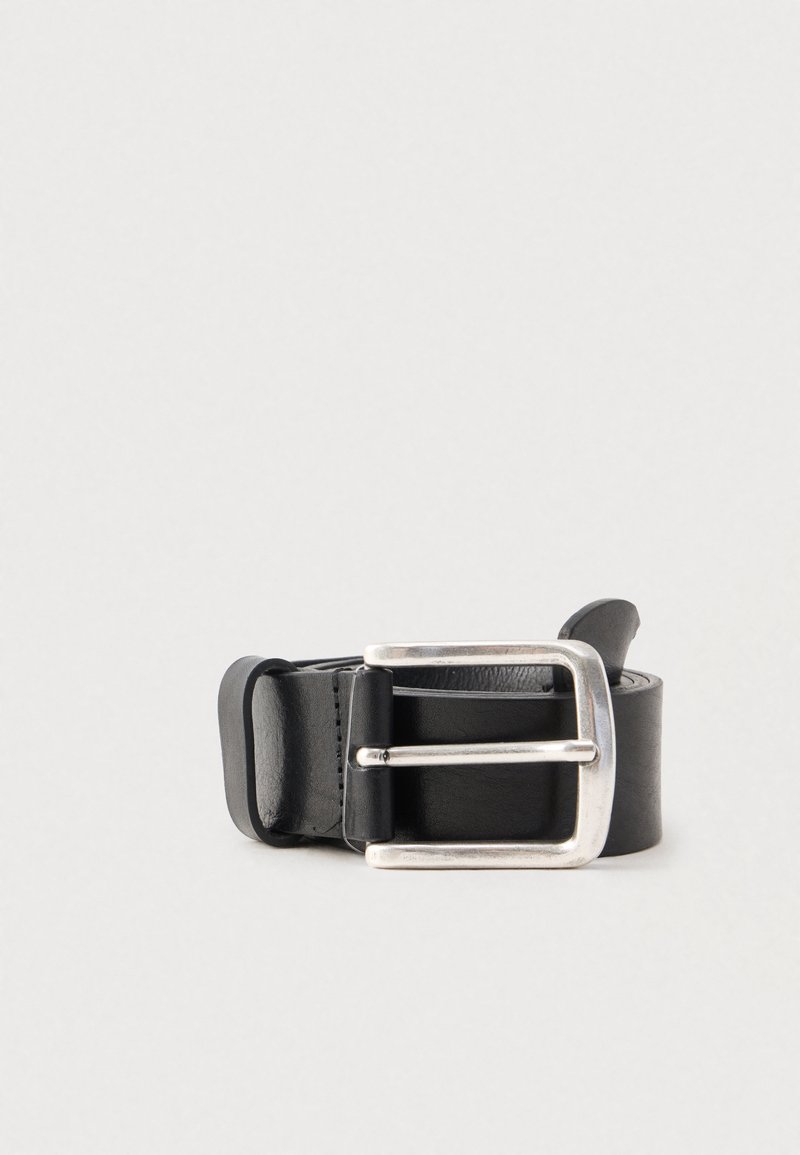 Melnas ādas josta ar sudraba metāla kvadrātveida sprādzi, gluda tekstūra un kārtīgi izšūtas malas. Minimālistisks dizains.