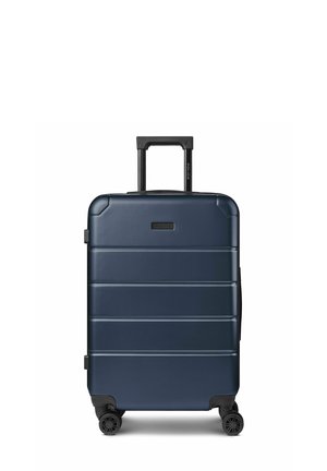 Valigia rigida blu navy con quattro ruote nere rotanti e manico telescopico nero esteso, vista frontale su sfondo bianco.