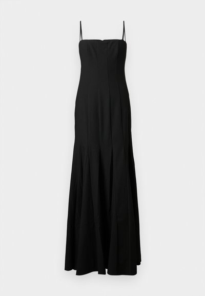 Hosszú fekete ujjatlan estélyi ruha vékony vállpántokkal és testhezálló felsőrésszel, amely bővülő szoknyába folyik.