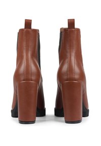 Brown leather ankle boots with a chunky heel, elastic side panels, and a pull tab at the back; black rubber sole for traction.