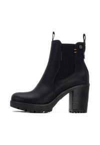 Botas de tobillo negras con tacón grueso, paneles laterales elásticos, acabado de cuero texturizado y tiradores en la parte posterior. Suela de goma duradera.