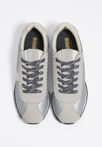 Szare i srebrne sneakersy z teksturowaną zamszową cholewką, zygzakowymi akcentami i szarymi sznurowadłami. Czarne gumowe podeszwy; wyściółka w otworach.