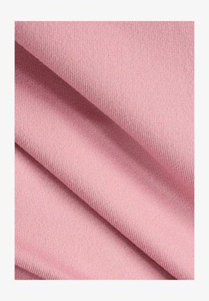 Zacht roze breiwerk, fijn van textuur met zichtbare stiksels. Meerdere plooien creëren diepte en benadrukken de elasticiteit en soepelheid van het materiaal.