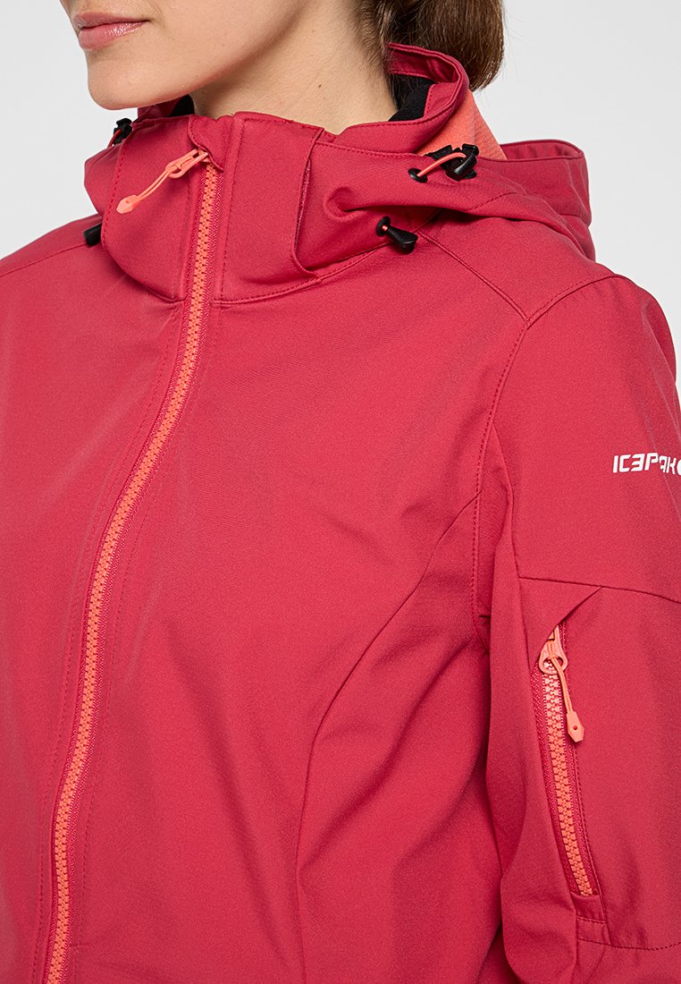 Rote Outdoor-Jacke mit durchgehendem Reißverschluss, verstellbarem Kapuzenansatz und Seitentaschen. Hergestellt aus glattem Material, mit kontrastierenden orangefarbenen Reißverschlussdetails.