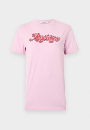 Jasnoróżowy T-shirt z krótkim rękawem, z napisem „Hot & Sweet Replay” oraz grafiką dwóch truskawek na środku klatki piersiowej.