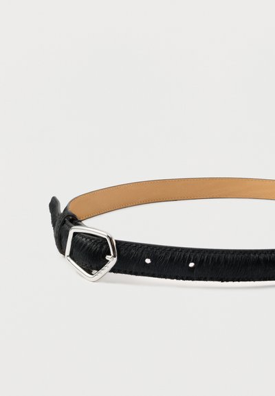 Μαύρη δερμάτινη ζώνη με ασημένια πόρπη σε σχήμα πεντάγωνου, που δείχνει δύο τρύπες ρύθμισης, ξαπλωμένη πάνω σε λευκό φόντο.