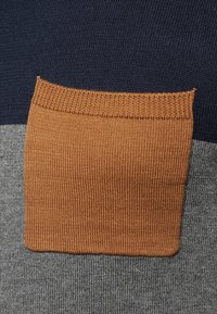 Stickad tröja med marinblå överdel, grå kropp och en rektangulär orange ficka. Har ribbade kanter och en slät textur.