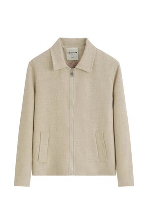 Veste en lin beige avec fermeture éclair intégrale à l'avant, col classique et deux poches frontales verticales, présentée sur fond blanc.