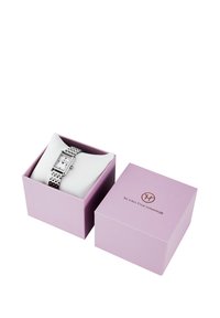 Silberne rechteckige Armbanduhr mit weißem Zifferblatt und römischen Ziffern auf weißem Kissen in einer geöffneten rosa Victoria Hyde London Box.