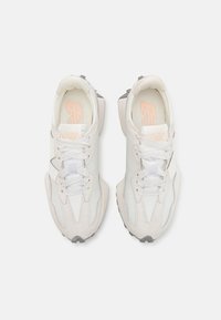 Weiße Sneaker aus einer Mischung aus weichem Leder und Wildleder, mit einem eleganten Design, runder Spitze und grauen Akzenten an Sohle und Ferse.