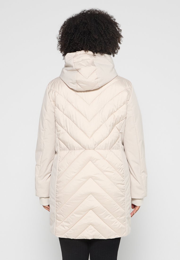 Beige Daunenjacke mit Kapuze, Zickzack-Steppmuster und langen Ärmeln. Glatte Textur mit lockerer Passform, die bis zur Mitte des Oberschenkels reicht.