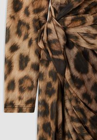 Tessuto con stampa leopardata che presenta tonalità di marrone e nero, con una texture drappeggiata e un materiale morbido e leggero sui dettagli delle maniche.