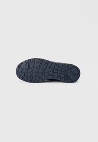 Rubber shoe sole in navy, featuring a textured, geometric pattern for traction, with a rounded toe and a slightly raised heel.