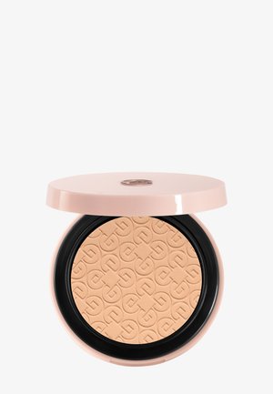 Poudre compacte beige pressée avec un motif géométrique embossé, contenue dans un boîtier rond rose pâle avec un couvercle partiellement ouvert.