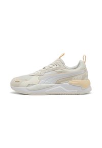 Beige sportieve schoenen met een textuurstof bovenwerk, witte accenten, een gevoerde kraag en een onderscheidend tussenzoolontwerp. Voorzien van een handige trekriem.